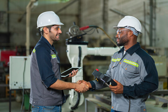 Two Industry engineers stand and discussion work in the factory workshop.