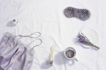 Healthy night sleep concept, pajamas, sleep mask, cup of lavender tea, aromas for better falling...