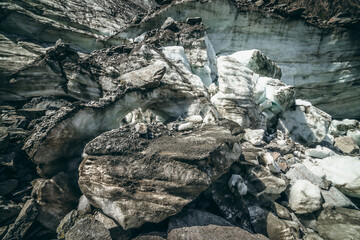 Nature background with icefall near glacier wall with cracks and scratches. Natural backdrop with icy wall and blocks of ice. Beautiful landscape with shiny glacial wall and ice blocks in sunlight.