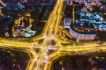 roundabout intersection in residential district at night. car light trails. long exposure. aerial...