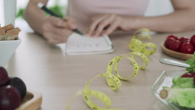 Women taking notes planning healthy menu. Women choosing foods that are healthy such as fruits and vegetables. The concept of healthy eating choices and diet