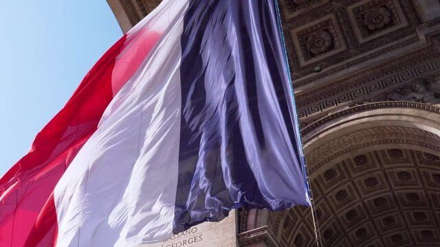 Close up of French flag flying in the wind under the Arc de Triomphe - Paris, France