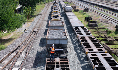 Taken photo from above, railroad engineers inspect railroad tracks and stone-carrying convoys for...