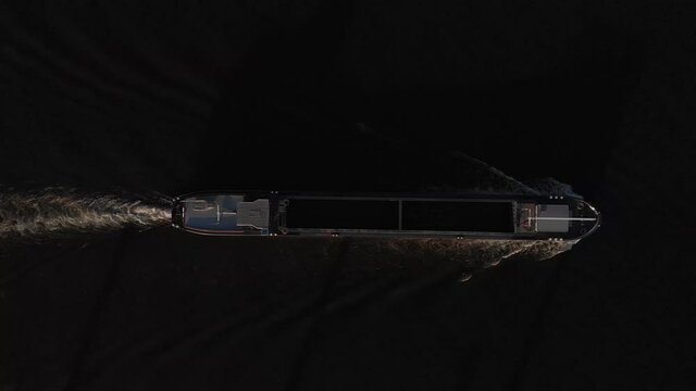 Graphic top down abstract minimalist aerial view of cargo ship leaving a wrinkled trail in the river IJssel water. Dutch inland transportation concept.