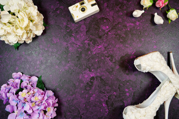 Wedding and bridal theme framed border flat lay with high heel shoes and bouquet on a purple...