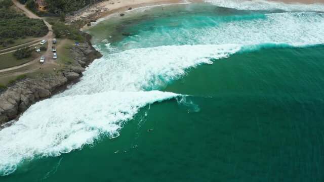 Birdseye drone shot of surfers at Tofinho Point, Mozambique.