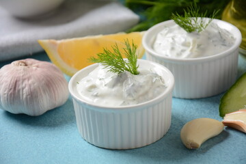 Traditional greek dip sauce or dressing tzatziki prepared with grated cucumber sour cream yogurt olive oil and fresh dill.