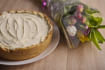 Fototapeta na wymiar Banana homemade cream pie and a bouquet of flowers