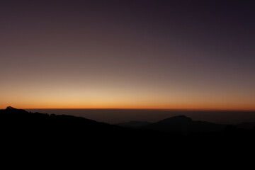 Obraz premium Rays of the orange sunshine on the top of the mountain
