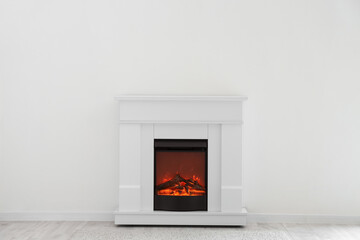 Stylish fireplace near light wall in room
