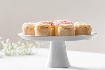 Dessert stand with tasty cupcakes on table