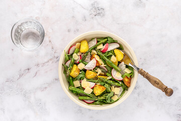 Summer salad with potatoes, green asparagus, arugula, and radishes. Seasonal diet food.