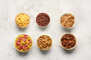 Bowls with different cereals on light background