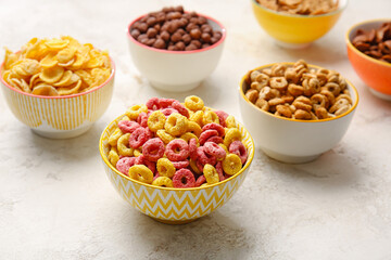 Bowls with different cereals on light background
