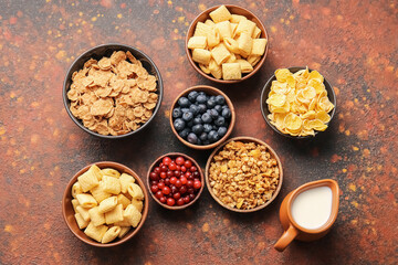 Composition with different cereals, milk and berries on grunge background