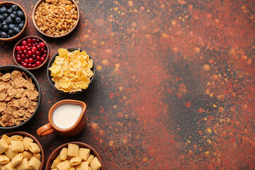 Composition with different cereals, milk and berries on grunge background