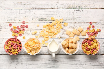 Fototapeta na wymiar Composition with different cereals and milk on light wooden background