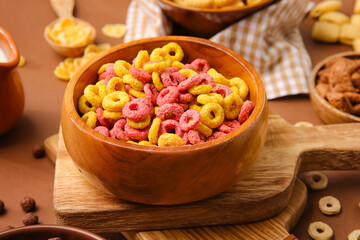 Bowl with tasty cereal rings on color background, closeup