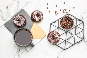 Composition with cup of coffee and donuts on marble background