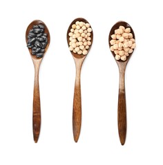 Spoons with different legumes on white background