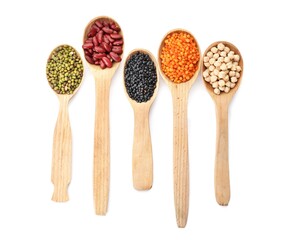 Spoons with different legumes on white background