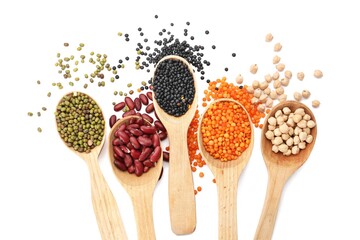 Spoons with different legumes on white background