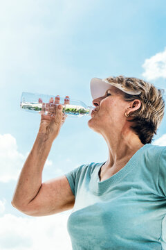 Senior Woman Drinking Water After An Exercise