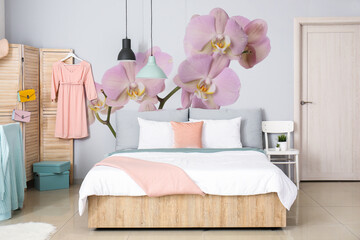 Stylish interior of bedroom with beautiful orchid flowers on wall