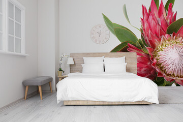 Stylish interior of bedroom with beautiful exotic flowers on wall - obrazy, fototapety, plakaty