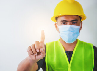 Engineer in medical mask touching transparent screen display with selectived focus on finger. Constructtion Concep.