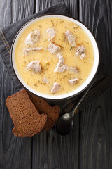 Artsoppa is a Swedish soup that is predominantly yellow split peas and meat close up in the plate on the table. Vertical top view from above