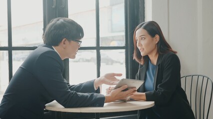 Obraz premium Happy two young businessman and woman successful meeting or negotiation with digital tablet sitting on desk cafe, Businesspeople discussion and smile lunch