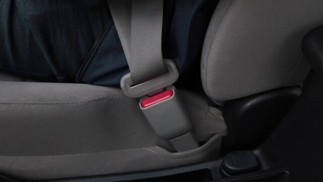 driver fastening seatbelt in vehicle before driving