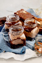 Trifles made with chocholate mousse and brownie on light gray background.