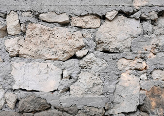 part of an old wall built of stone blocks and firmly bonded with cement
