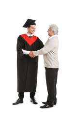 Happy male graduation student with his father on white background