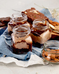 Trifles made with chocholate mousse and brownie on light gray background.