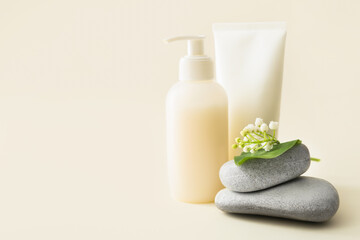 Composition with cosmetic products, stones and lily-of-the-valley flowers on color background