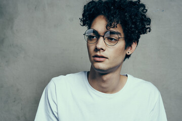 man with curly hair wearing glasses emotions white t-shirt studio