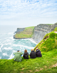 Menschen sitzen entspannt am Cliffs of Moher in Irland Meer Ozean Küste Atlantik Klippen Felsen Landschaft Natur / Ireland, Sea Ocean Coast Atlantic Cliffs Rock Landscape Nature people 
