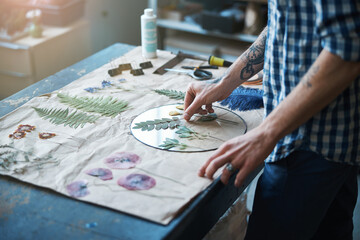 Obraz na płótnie Canvas Young man making glass herbarium in workshop