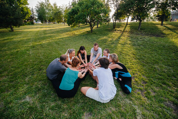 A group of people do yoga in a circle in the open air during sunset. Healthy lifestyle, meditation...