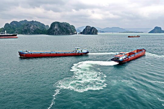Seagoing vessels, barges, tugboats and small boats at the roadstead of Halong bay under cargo operations and underway. Port of Campha, China. Vietnam, October, 2020