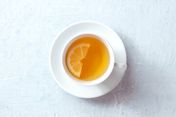 A cup of tea with a slice of lemon, shot from the top on a slate background. The concept of a...