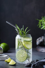 Hard seltzer cocktail with lime, rosemary and bartenders accessories