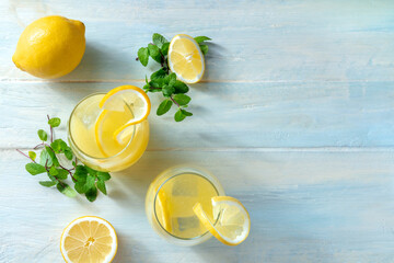 Lemonade flat lay with copy space. Homemade fresh drink with lemon and mint, overhead on a wooden...