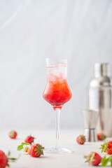 Strawberry liqueur with ice in a glass. Summer refreshing alcoholic drink