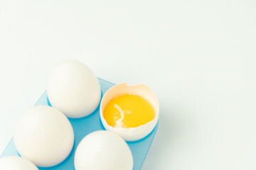 Chicken eggs and one broken egg with yolk