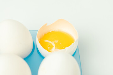 Chicken eggs and one broken egg with yolk
