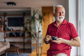 Senior man, relaxing and having his favorite drink.